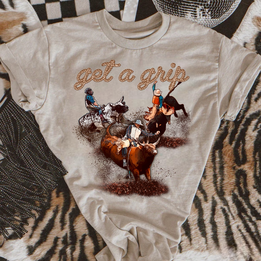 Get a Grip Rodeo Bull Riding Graphic on Gildan Softstyle Natural Shirt – Graphic Tee, Long Sleeve & Crewneck.